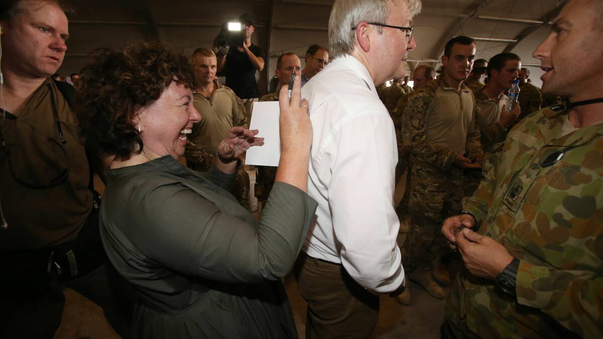 Therese Rein signs a get well soon card for an Australian soldier. Photo: Gary Ramage/pool